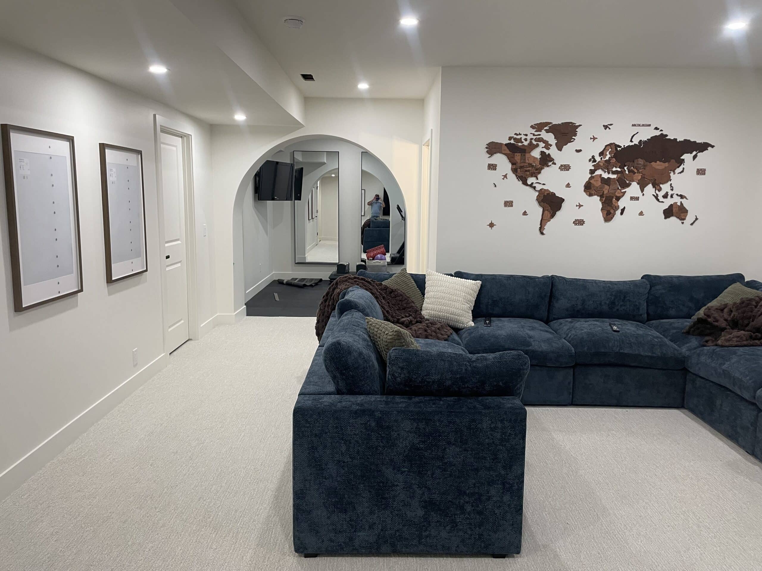 Finished Garrison Green Calgary basement living room with custom archway, sectional sofa and recessed lighting