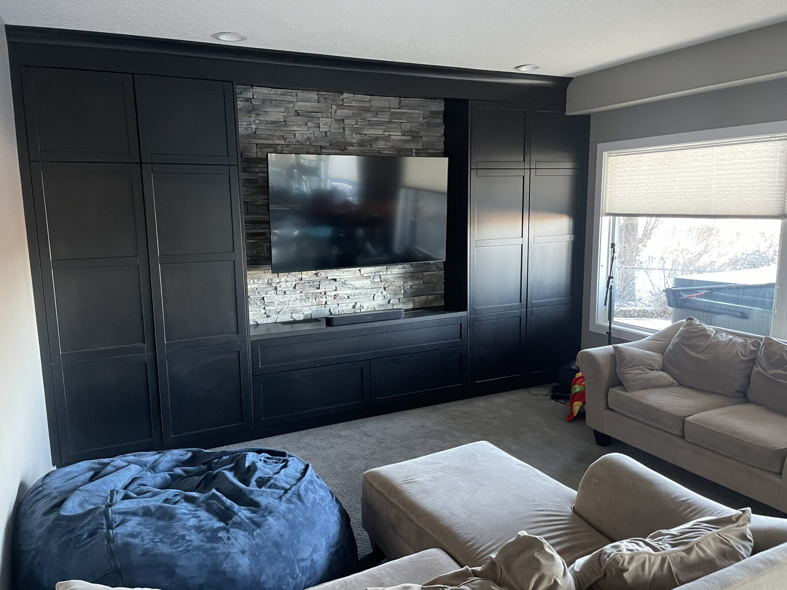 Custom TV wall cabinetry and stone feature in Mt Douglas Cir SE Calgary basement renovation